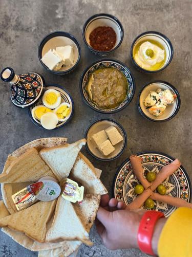 una persona che tiene in mano un piatto di cibo con uova e pane di فندق المسافر a Riyad