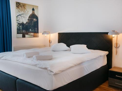 a large white bed with two white pillows on it at Ionesco Apartments in Cluj-Napoca