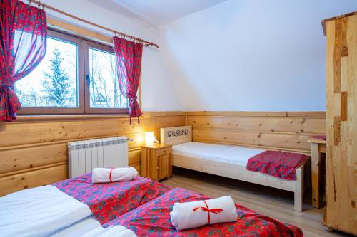 a bedroom with two beds and a window at Góralski domek nad Białką in Jurgów