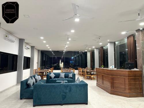 a living room with two blue couches and a table at Golden Pearl Resort By Gemstone Hospitality in Alibag