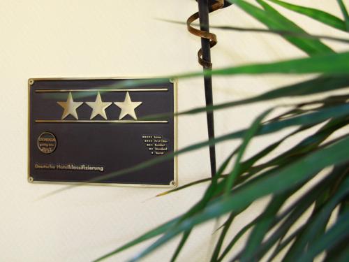 a sign with four stars on it next to a plant at Hotel Weisse Düne in Borkum
