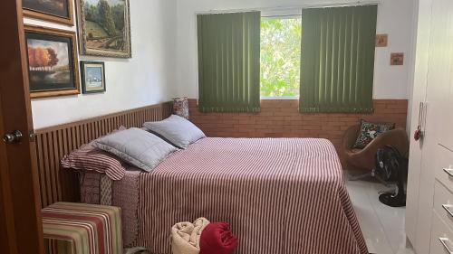 a small bedroom with a bed and a window at Sítio Sapiranga in Sapiranga