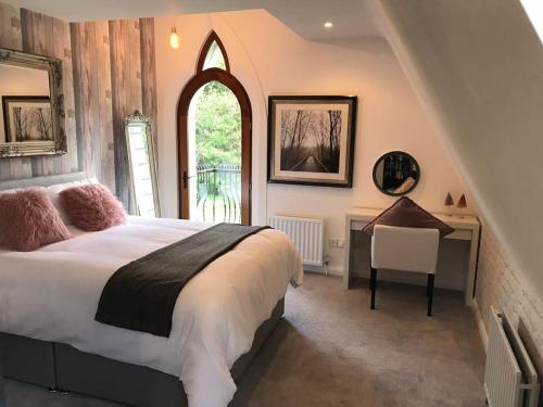 um quarto com uma cama, uma secretária e uma janela em Old Schoolhouse, Galgorm (Annexe) em Galgorm