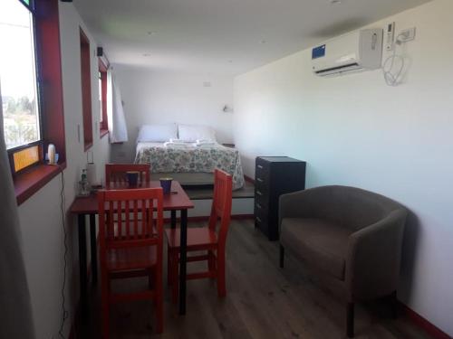 a small room with a bed and a table and chairs at El Abrigo in El Calafate