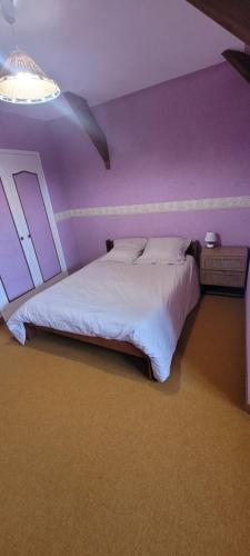 濱海聖洛朗的住宿－Omaha beach vue les Braves，一间卧室配有一张大床和紫色墙壁