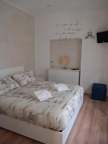 a bedroom with a white bed with a white wall at La casa di Orso in Velletri