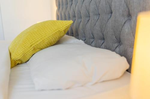 a yellow pillow sitting on top of a bed at 2 Double Beds - 2 Single Beds in Manchester