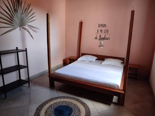 a bedroom with a bed with white sheets and a plant at KIBA HOTEL in Hell-Ville
