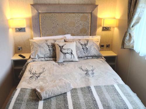 a bedroom with a bed with deer pillows at Forest Getaway, sleeps 6 at Bashley, leisure PASS included in New Milton