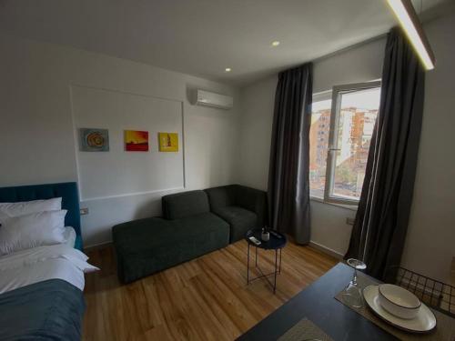 een woonkamer met een groene bank en een raam bij Tirana Elegant Apartment in Tirana