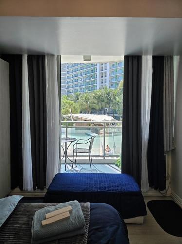 um quarto com 2 camas e vista para uma varanda em Cozy Staycation - Azure Urban Resort Residences em Manila