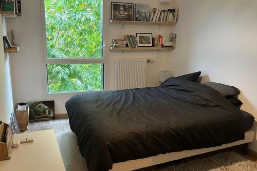 une chambre avec un lit et une grande fenêtre dans l'établissement bel appartement proche centre et lac, à Annecy