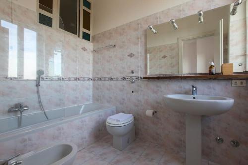 a bathroom with a sink and a toilet and a tub at HACCA Collection - Isola 1BR in Milan