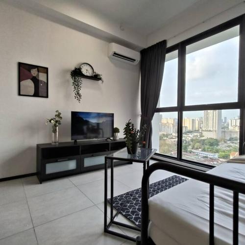 a living room with a tv and a bed and a table at New Urban Suite Majestics 3BR Homestay at Georgetown BY URBAN STAYCATION HENG LOD in Jelutong