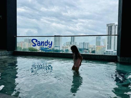 a woman standing in the water in a swimming pool at New Urban Suite Majestics 3BR Homestay at Georgetown BY URBAN STAYCATION HENG LOD in Jelutong