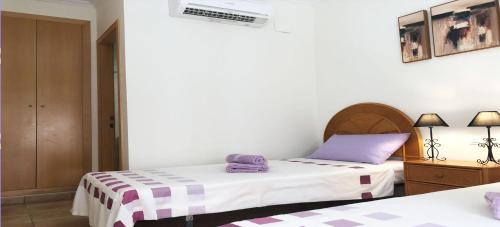 two beds in a room with purple and white sheets at Appartement Mar y golf in Pedreguer