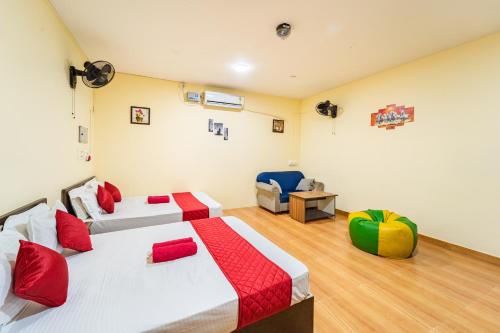 a hotel room with two beds and a chair at Le Mission Stay in Pondicherry