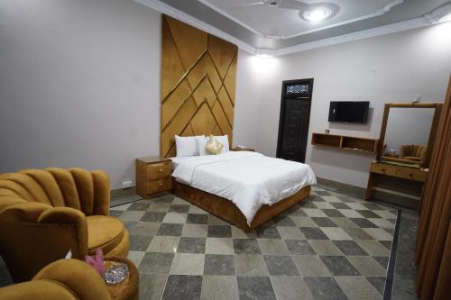 una camera con letto, sedia e televisore di Karachi Guest House Johar a Karachi