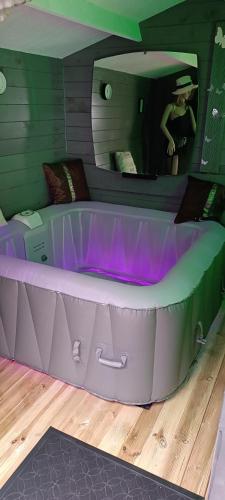 eine Badewanne mit violettem Licht in einem Zimmer in der Unterkunft LOVE ROOM Cabane des charmes in Andernos-les-Bains