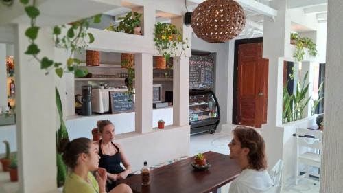 three women sitting at a table in a restaurant at Casa Oro Eco Hostel in San Juan del Sur