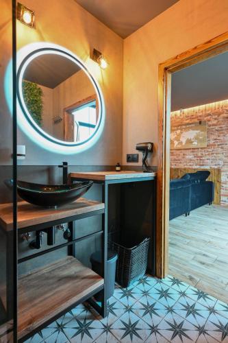 a bathroom with a sink and a mirror at Aparthotel Mamma Mia - Oświęcim in Oświęcim