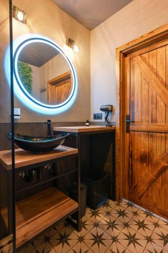 a bathroom with a sink and a mirror at Aparthotel Mamma Mia - Oświęcim in Oświęcim