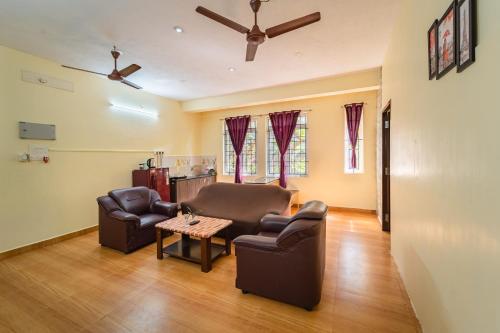 a living room with two chairs and a table at Le Mission Stay in Puducherry