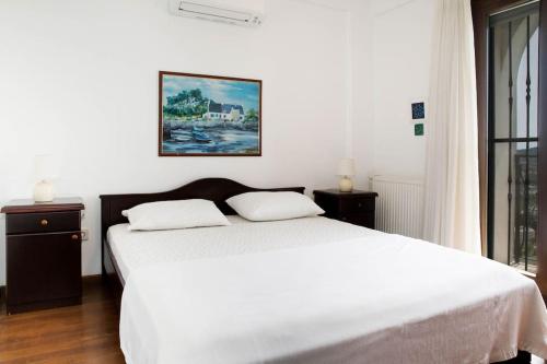 a bedroom with a white bed with two pillows at Villa Rana by Important Group Travel in Yalıkavak