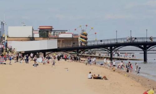 a group of people on the beach near a pier at Spacious Seaside House in Cleethorpes