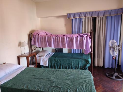 1 dormitorio con 2 camas y dosel rosa en Edificio Dean Funes 321 en Salta