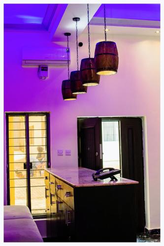 a purple kitchen with a counter and some pendant lights at House 7A in Enugu