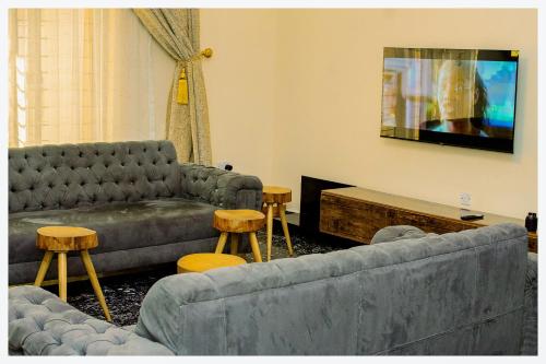 a living room with two couches and a flat screen tv at House 7A in Enugu