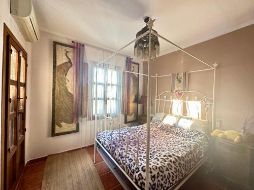 een slaapkamer met een bed met een metalen baldakijn bij Habitación Onda con piscina privada in Ciudad Quesada