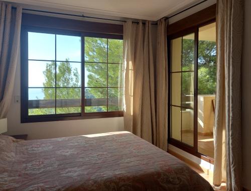 a bedroom with a bed and a large window at Townhouse Altea Hills in Altea