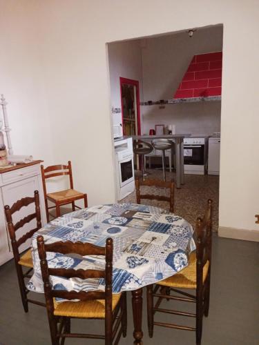 una sala da pranzo con tavolo e sedie e una cucina di chateau du ponthereau a Massay