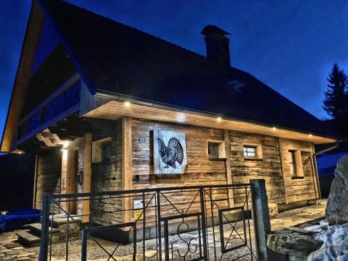 a log cabin with a clock on the side of it at Ein JUWEL "zum-Auerhahn" in Modriach