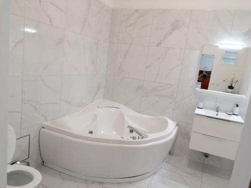 biała łazienka z wanną i toaletą w obiekcie Kaela spa balneo w mieście Le Port