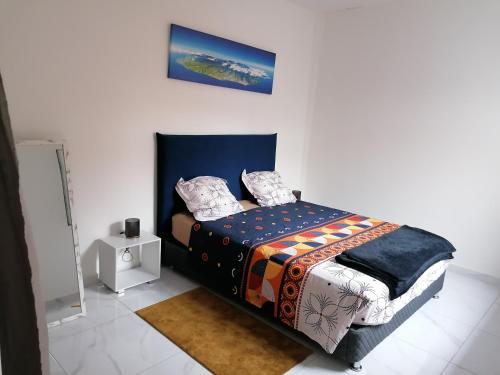 sypialnia z łóżkiem z niebieskim zagłówkiem w obiekcie Kaela spa balneo w mieście Le Port