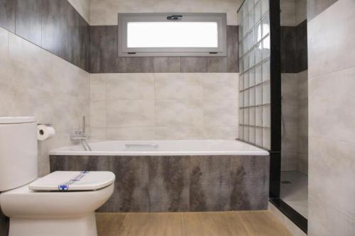 a bathroom with a toilet and a bath tub at L Estel del Riu in La Cava