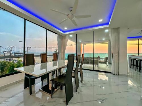 a dining room with a table and chairs and the ocean at STUNNING BEACHFRONT VIEW LUXURIOUS Apartment 30 in Jomtien Beach