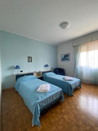 two beds in a room with blue walls at Spazio Friuli - Soreli Apt residenza nel verde in Sevegliano