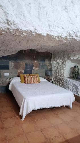 阿爾卡拉胡卡的住宿－Casas Alcala，卧室配有石墙内的白色床