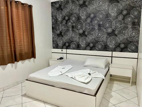 a bedroom with a bed and a wall with a flower pattern at Hotel Sunshine in São Bernardo do Campo