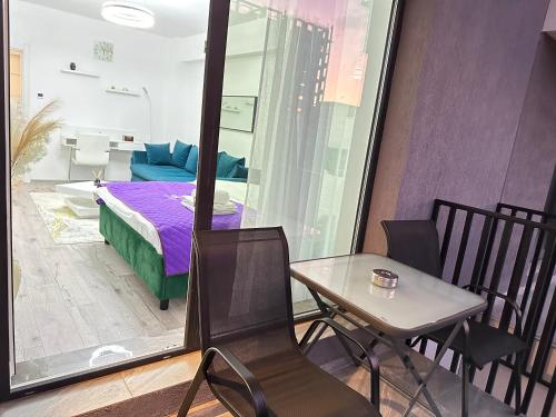 Coresi Mall Area Studios & Apartments by GLAM في براشوف: غرفة بسرير وطاولة وكراسي