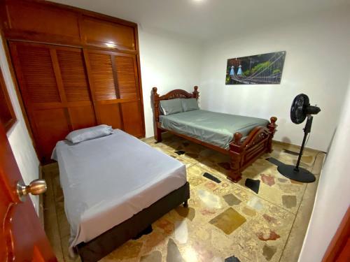 a bedroom with two beds and a lamp in it at Casa EstadioMed in Medellín