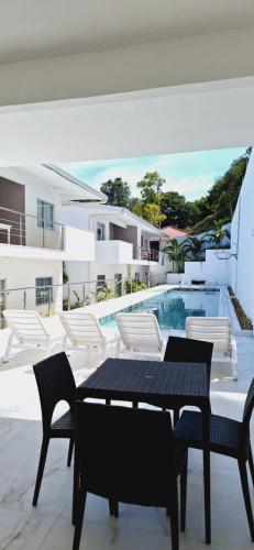 d'une terrasse avec une table et des chaises à côté de la piscine. dans l'établissement Residencial aconchegante- Taperapuan, à Porto Seguro