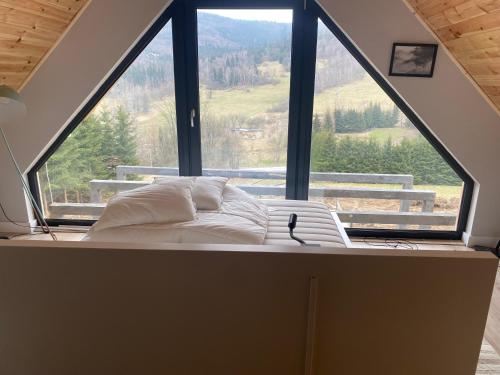 a bed in a room with a large window at DOMKI NA SKARPIE in Rzeczka