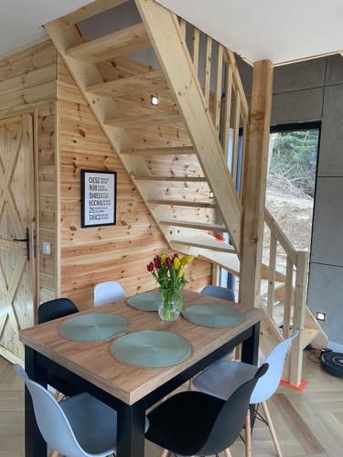 a dining room with a wooden table and chairs at DOMKI NA SKARPIE in Rzeczka