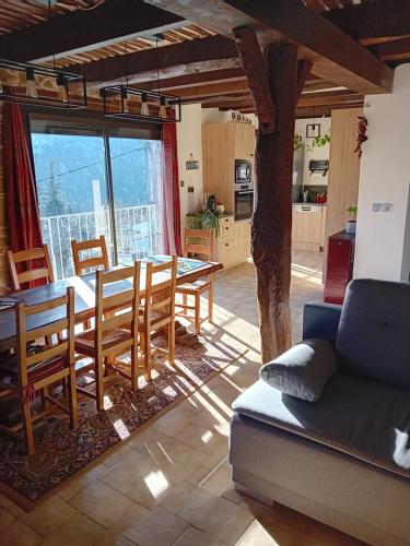 un salon avec une table, des chaises et un canapé dans l'établissement appartement independant avec piscine privee, à Lantosque