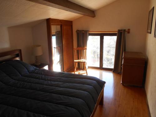 une chambre avec un grand lit et une fenêtre dans l'établissement appartement independant avec piscine privee, à Lantosque